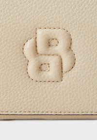 Beige bőr pénztárca domborított iniciálékkal, lekerekített élekkel, finom textúrájú felülettel és kontrasztos varrási részletekkel.