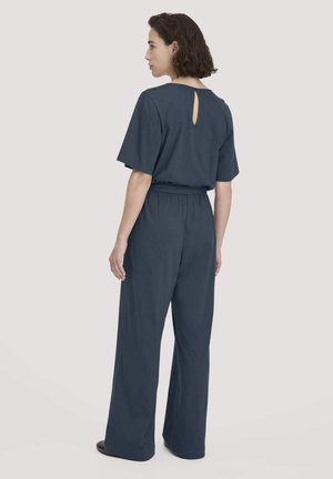 Marineblauwe jumpsuit met korte mouwen, elastische taille, wijd beenontwerp en een sleutelgatdetail op de rug. Zachte stoftextuur.