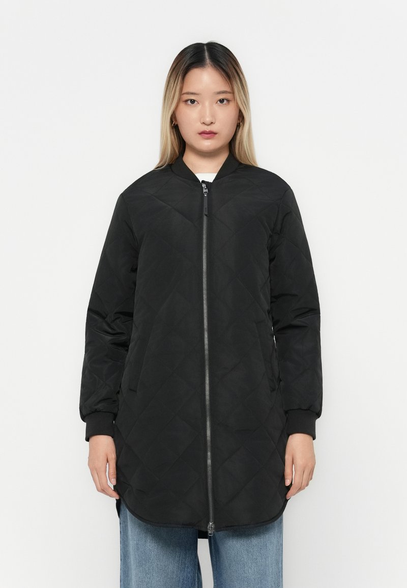 Black quilted long jacket with a zip closure, ribbed cuffs, and side pockets. Features a round neckline and a straight hem.