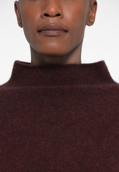Burgundi kõrge kaelusega sviiter, mis on valmistatud pehmest kudumismaterjalist, omades sujuvat tekstuuri ja minimalistlikku disaini ilma nähtavate mustriteta või metalldetailideta.