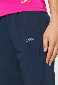 CMP sportswear featuring a pink top and navy blue pants. The fabric is smooth, with a prominent CMP logo on the pants in silver.
