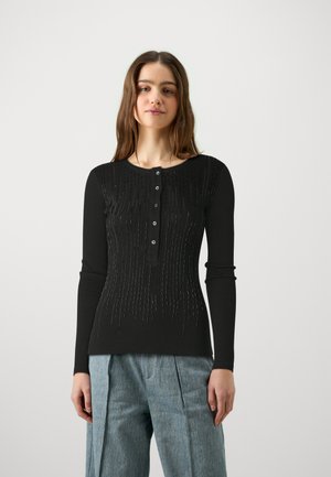 Zwarte longsleeve top met een ronde hals, voorzien van een knoopsluiting en verticale textuurdetails voor extra diepte.