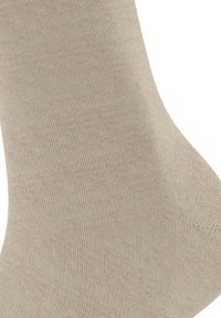 Calzino beige realizzato in tessuto testurizzato, caratterizzato da una finitura liscia e un motivo a costine, design affusolato con punta arrotondata e tallone rinforzato.