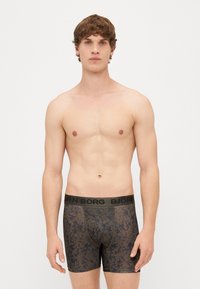 Sötét mintás boxeralsó fekete rugalmas derékkal, amin a "BJÖRN BORG" logó található. Puha anyag, testhezálló kialakítás, középmagasságú.