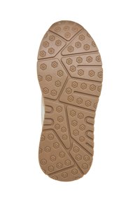 Semelle en caoutchouc marron crantée d'une chaussure avec des motifs hexagonaux et linéaires pour l'adhérence, vue du dessous sur fond blanc.