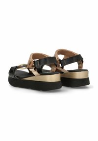 Sandalias de plataforma negras y doradas con correas texturizadas, hebillas ajustables y una suela de goma negra sólida. El diseño cuenta con un dorso y lados abiertos.