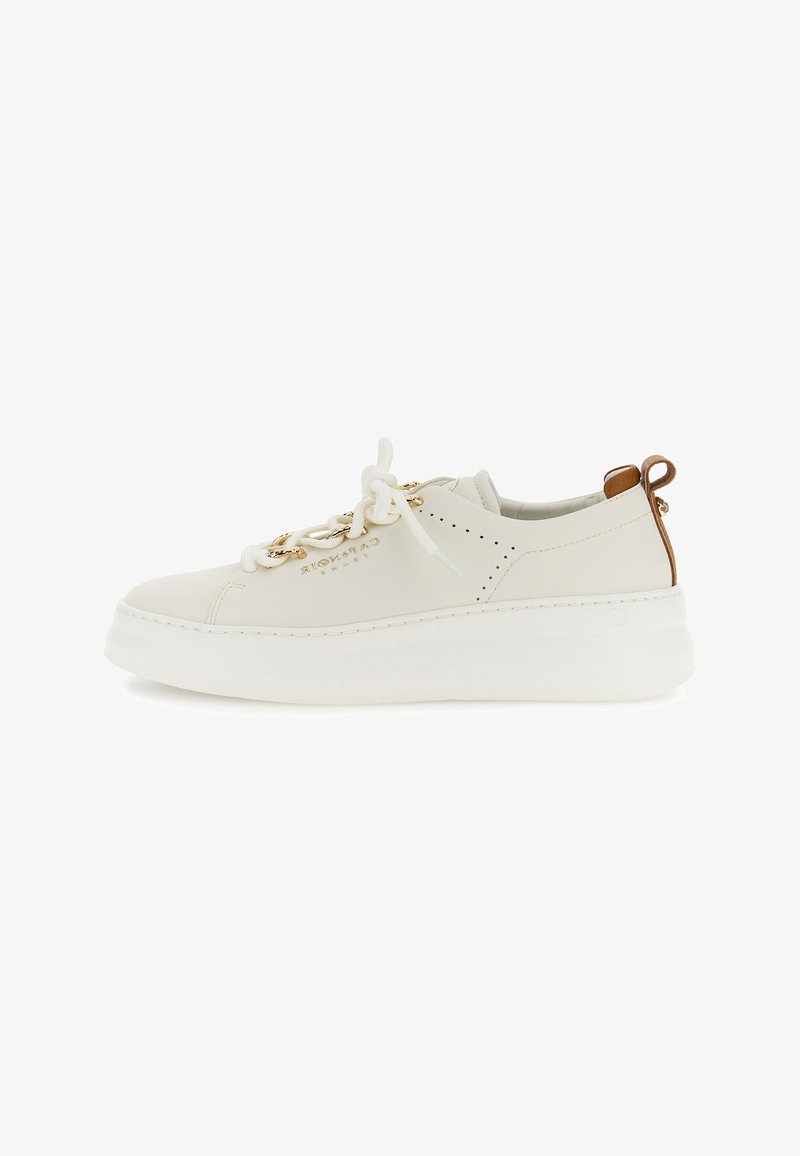 Beige lage sneaker met dikke witte zool, gouden kettingdetail op de veters, geperforeerde zijkant en bruine treklus aan de hiel.