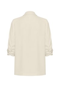 Blusa color crema con una texture morbida, caratterizzata da un colletto classico e maniche arricciate. La vista posteriore evidenzia un design a vestibilità rilassata.