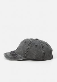Graue Denim-Kappe mit einem gebogenen Schirm, gestickten Buchstaben auf der Vorderseite und sechs Belüftungsösen. Verstellbarer Riemen auf der Rückseite.