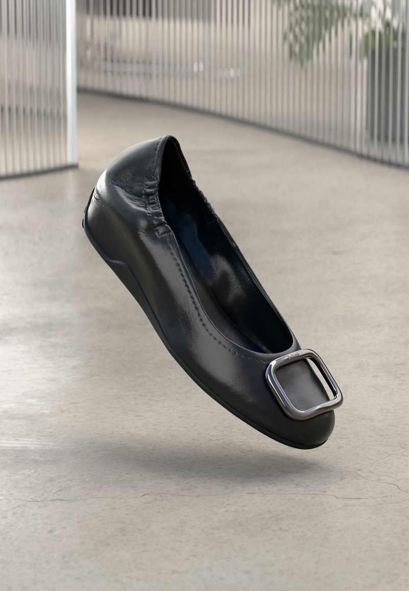 Black patent leather ballet flat with a rounded toe and a metallic rectangular buckle accent. Smooth finish, no visible stitching details.