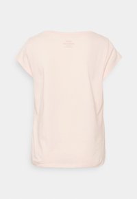 T-shirt rosa chiaro in cotone, con maniche corte, scollatura rotonda e un logo discreto stampato sul retro. Texture liscia.