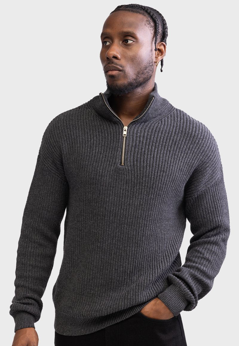 Dark gray zip-up sweater with a ribbed texture, high collar, and gold zipper detail.