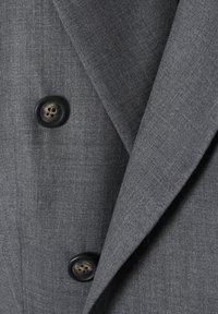 Grijze stoffen blazer met een soepele textuur en gestructureerde revers. Voorzien van twee ronde zwarte knopen met een houtachtige details in het midden.