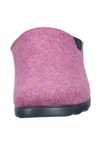 Felt slipper in bright pink with a rounded design, smooth black sole, and a blue branding tag on the side. Soft texture.
