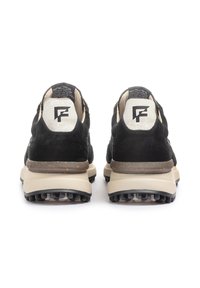 Sneaker in suede nera con suola in gomma beige e battistrada nera. Presentano un logo bianco sul tallone e dettagli testurizzati sulla parte superiore.