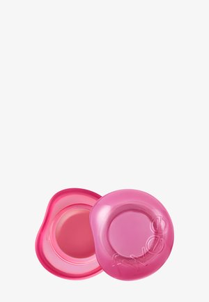 Deux contenants ronds roses de baume à lèvres, l'un ouvert montrant un baume lisse à l'intérieur, l'autre fermé avec un couvercle translucide embossé de "AWAKE".