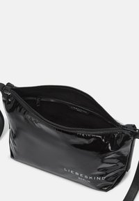 Borsa a spalla in pelle verniciata nera con chiusura a zip, texture liscia, hardware in argento e logo "LIEBESKIND BERLIN" sul fronte.