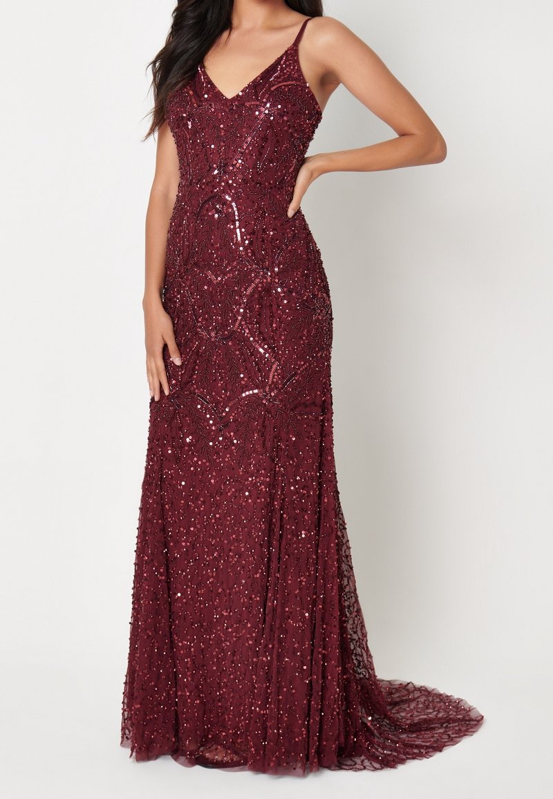 Burgundin iltamekko, jossa on V-aukko ja ohuet saumahihnat, koristeltu yksityiskohtaisella helmityöllä ja laajenevalla pitsihelmalla. Tyylikäs ja muotoiltu siluetti.