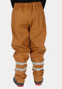 Bruine waterdichte broek met een elastische tailleband, voorzien van twee reflecterende strepen vlak bij de enkel en een gladde textuur.