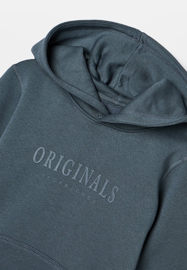 Bluza z kapturem w ciemnym turkusie o miękkiej fakturze. Posiada wyraźne logo "ORIGINALS" oraz klasyczny projekt z rozcięciem na głowę i ściągaczami na rękawach.