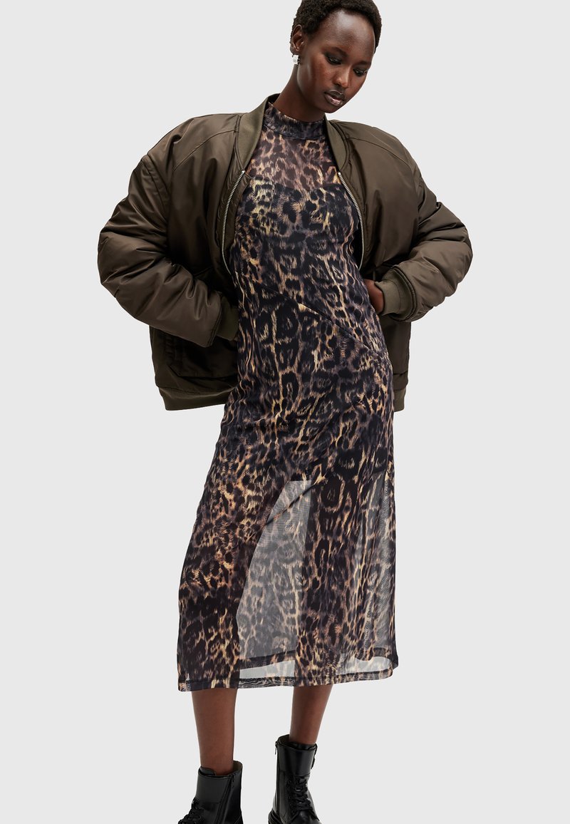 Φόρεμα με λεοπάρ σχέδιο και διάφανη υφή, συνδυασμένο με ένα ελαιόχρωμο bomber μπουφάν. Μαύρες μπότες μέχρι το αστράγαλο ολοκληρώνουν το ντύσιμο.