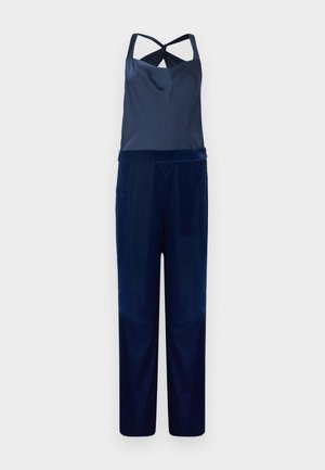 Jūros mėlynos spalvos petnešų kostiumas su satino viršumi ir aksominėmis plačiomis kelnėmis. Yra kryžminė nugaros dalis ir glotni tekstūra. Prisiūtas siluetas, be raštų.