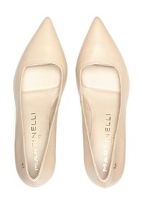 Zapatos beige de punta afilada con recortes en los laterales, hechos de cuero suave, con un logotipo dorado en las plantillas y un diseño minimalista.