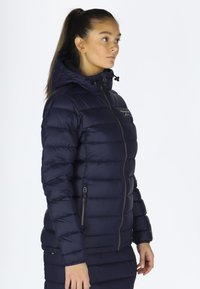 Navy puffer jacket with a hood, made from a quilted, shiny material. Features a front zipper and zippered side pockets.