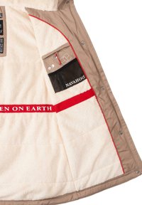 Beige Jacket, gefüttert mit cremigem Fleece, mit roten Details und einer Netztasche mit der Aufschrift "NAVAHOO". Enthält Stauraum für Kopfhörer und Zubehör.