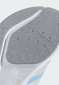 Semelle de chaussure en caoutchouc gris avec des motifs texturés, semelle intermédiaire blanche et bande d'accent bleu clair. Comprend des points de grip circulaires et des nervures.