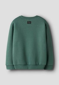 Grön crewneck sweatshirt med ribbade muddar och nederkant, med en liten svart etikett med vit text centrerad nära halsringningen på baksidan.