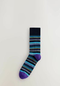 Üksik sokk, millel on horisontaalsed triibud sinises, mustas, hallis, kollases ja lillakas värvitoonis, mille varvaste ja kontsa osa on lilla.