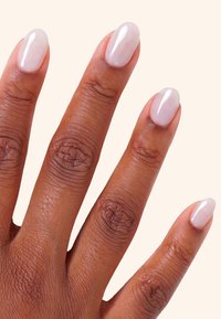 Manicura mostrada en una mano de piel marrón media; uñas en forma de almendra, de color rosa claro con acabado brillante y piel natural con textura.