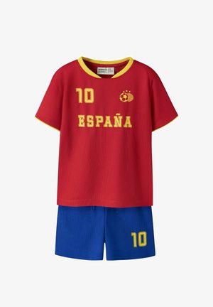 Rød spansk fodboldtrøje med gult kantbånd, nummer 10 og boldemblem, kombineret med blå shorts også med nummer 10 i gult.