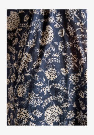 Námořnická látka s složitými bílými květinovými a listovými vzory; obsahuje různé tvary květin a detailní akcenty po celém designu.