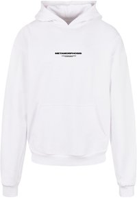 Weiße Kapuzenjacke aus weichem Stoff mit einer Fronttasche, auf der die schwarze Aufschrift "METAMORPHOSE" über der Brust gedruckt ist.
