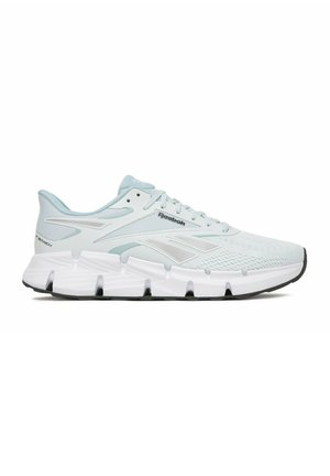 Zapatilla de running Reebok en gris claro y blanco con parte superior texturizada, cierre de cordones, entresuela acolchada y suela negra, vista desde un lado.
