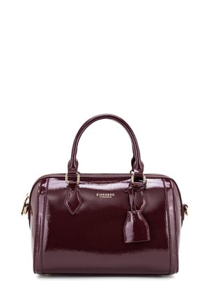 Borsa a mano in pelle verniciata bordeaux con doppio manico, hardware dorato e un piccolo tag decorativo. Design compatto e strutturato con una finitura lucida.