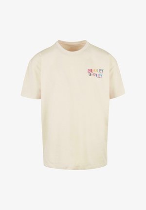 Beige-cotton t-paita pyöreällä kaula-aukolla ja lyhyillä hihoilla. Vasemmassa rintakehässä on värikäs "Holly Jolly" -grafiikka.