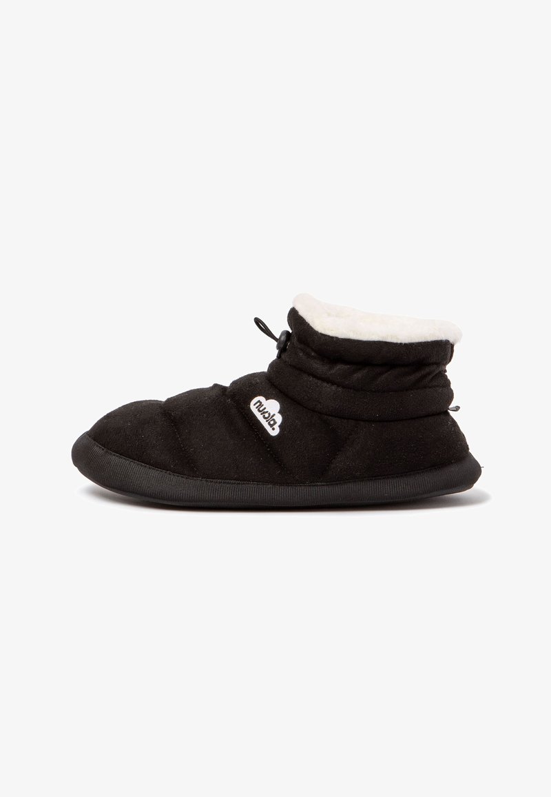 Pantuflas negras acolchadas con un cuello blanco de felpa, suela de goma y un toggle elástico para un ajuste ajustable, con un pequeño logo en el lateral.