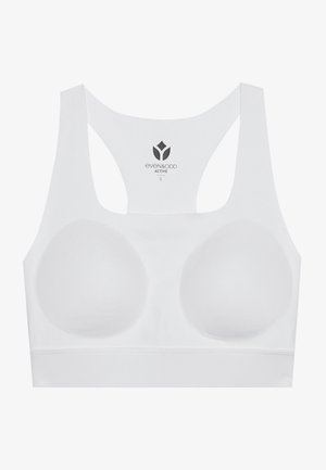 Bela športna modrček z oblikovanimi skodelicami, širokimi naramnicami in gladko teksturo. Ima logotip na notranji strani. Minimalistična zasnova in brezšivni končni izgled.