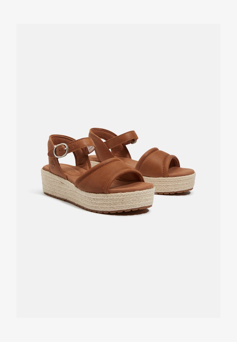Brown leather platform sandals with a textured jute midsole, wide front straps, and adjustable ankle strap featuring a metal buckle.