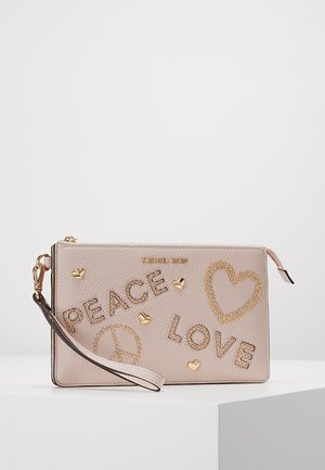 Beige Michael Kors håndledstaske med guldbelagte nitter, der staver "PEACE" og "LOVE", guldfarvede hjerte- og fredstegnspynt og en håndledsrem.