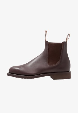 Stivale Chelsea in pelle marrone con pannelli laterali elasticizzati, punta tonda e linguette per infilarsi. Tacco basso a blocco con suola testurizzata per una presa sicura.