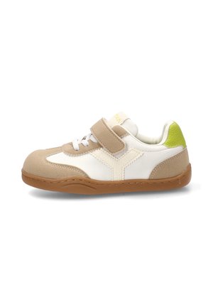 Zapatilla para niños de color beige y blanco con cierre de velcro, detalles de cordones, suela de goma y lengüeta trasera verde lima, mostrada de perfil.