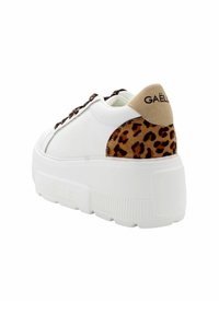 Sneaker bianco con suola spessa, dotata di un tallone in suede color tan e dettagli in stampa leopardata. I lacci sono di colore marrone scuro, con il marchio "GAËL" sul tallone.