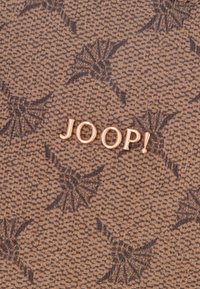 Materiale marrone testurizzato con un motivo sottile e il logo dorato "JOOP!" in rilievo al centro.