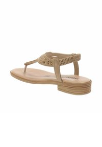 Sandalo thong beige con dettagli intrecciati, suola piatta, lieve arco e accenti metallici. Cinghie testurizzate e retro elastico per una buona vestibilità.