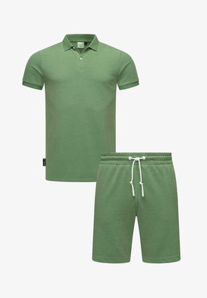 Polo verde e pantaloni corti abbinati, entrambi in un tessuto morbido con una finitura texturizzata. Caratterizzati da un colletto, chiusura a bottoni e vita con cordoncino.