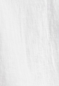 Tissu blanc texturé avec des motifs de tissage visibles et de subtiles plis verticaux.